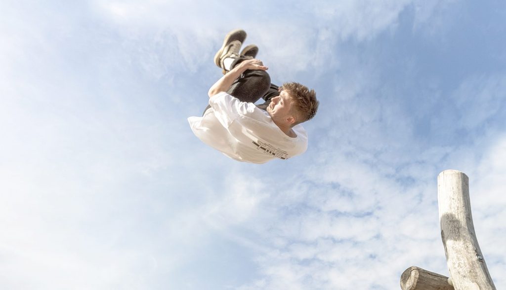 Boy doing a backflip in Front of the sky